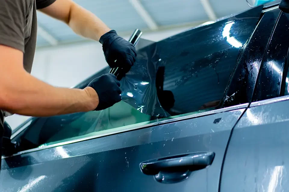 a-car-mechanic-carefully-sticks-a-protective-tinte Speedy Auto Glass Near Me: Common Auto Glass Issues We Handle