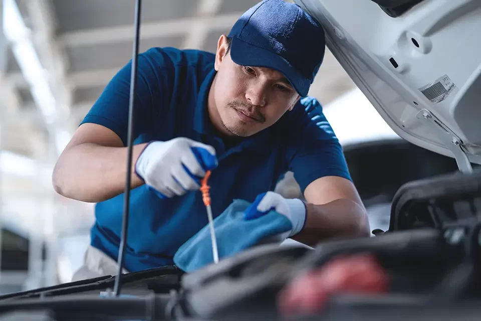 a-man-in-a-blue-shirt-is-working-on-a-car-engine Why Trust Us for Expert Car Painting Services Near Elgin Mills Road?