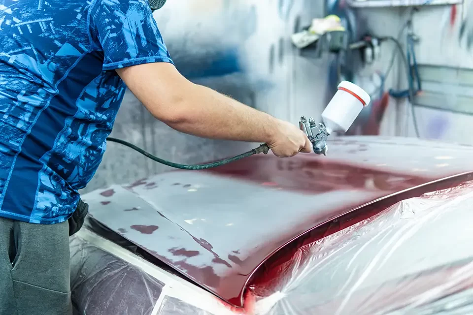 auto-mechanic-painting-a-red-car-in-a-workshop Why Auto Stars Collision & Mechanic is Among the Top Auto Body Repair Shops