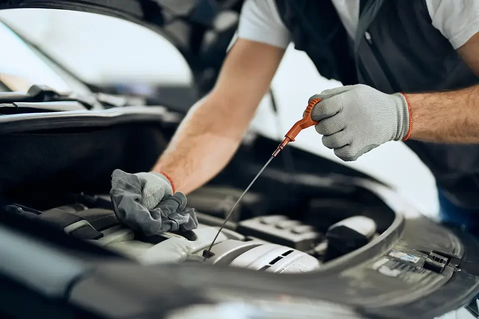 close-up-of-auto-repairman-checking-oil-level نکات مهم قبل از خدمات صافکاری و نقاشی خودرو