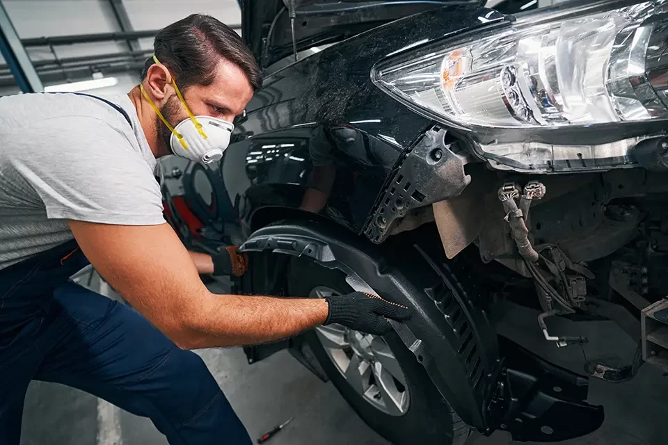 man-pulling-out-car-wheel-arch-cover Why Choose Our Nowruz Special Oil Change & Service?