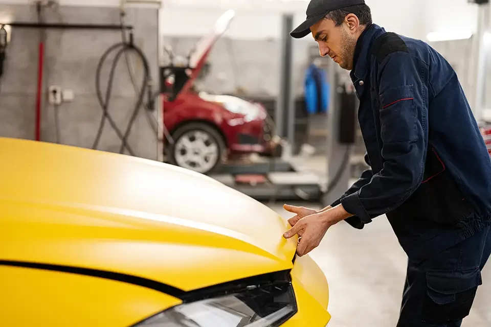 mechanic-open-hood-of-yellow-sport-car-suv Why Quality Matters in Auto Body Shops Close to You