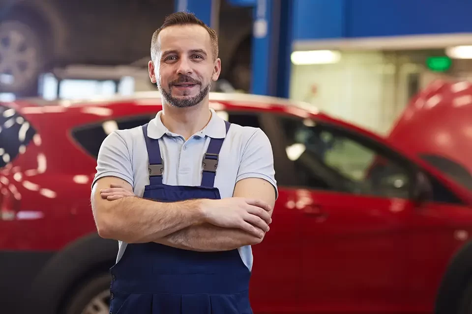 mechanic-posing-with-red-car The Process of Scratch & Dent Car Repairs