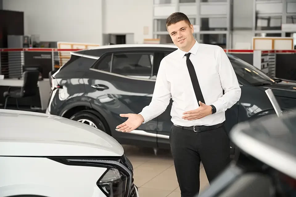 sales-manager-standing-in-car-showroom-presenting Auto Stars Collision & Mechanic and TD Insurance: A Partnership for Your Benefit