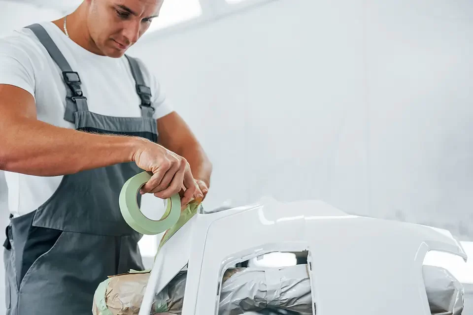works-with-car-hood-caucasian-automobile-repairma Common Causes of Bumper Paint Damage